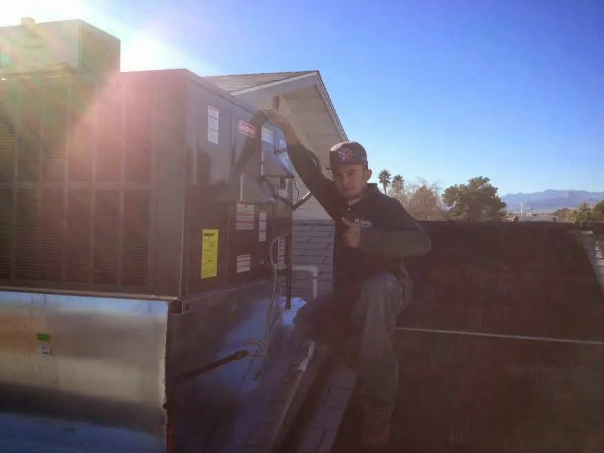 HVAC technician performing AC Tune-Up on a rooftop unit in Atascadero